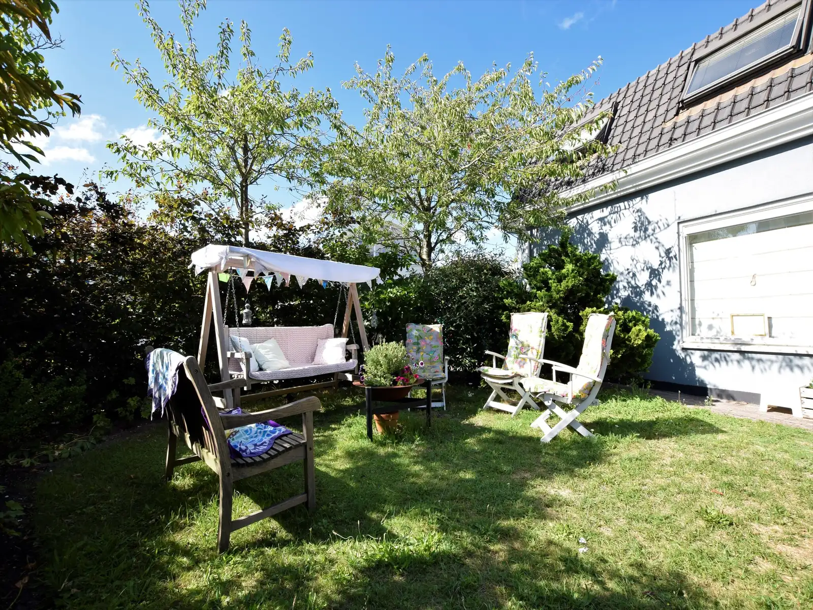 De besloten tuin met schommelbank